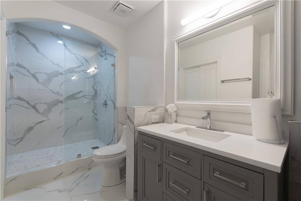 3445 Stratford Road Northeast, Unit 2107 Atlanta, GA 30326 - Photo 12 of 22 a bathroom with a sink a toilet and shower