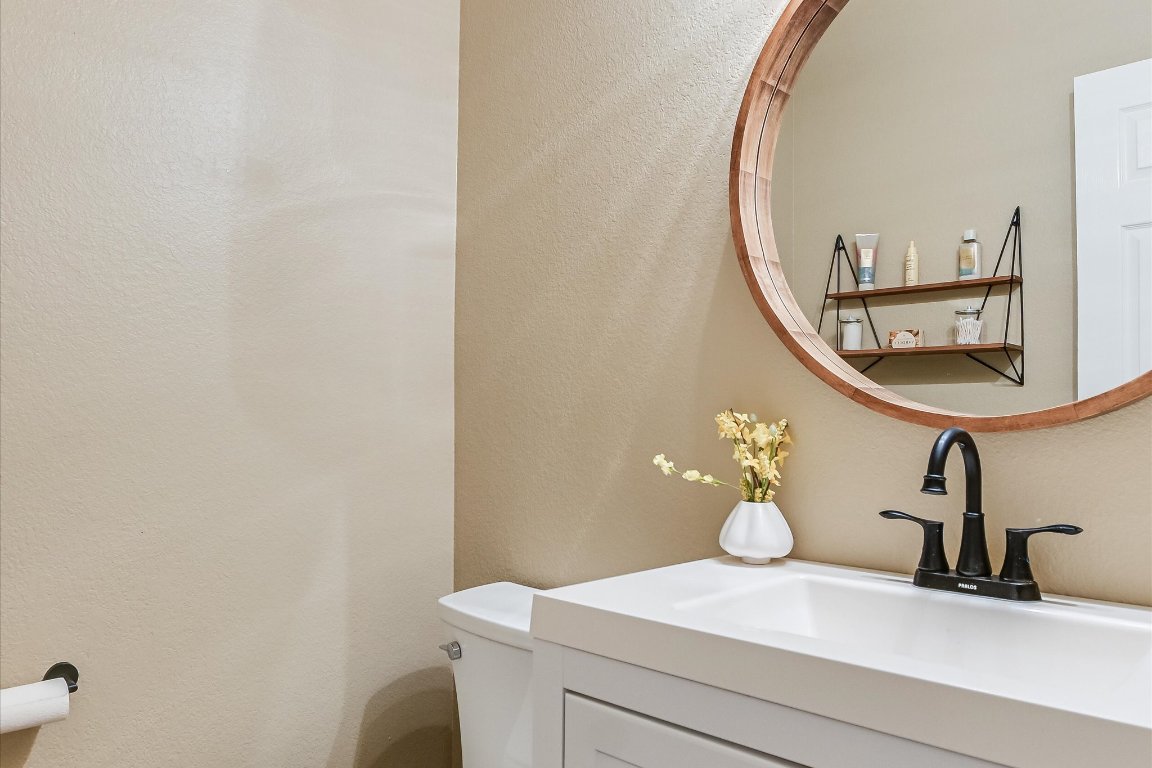 3231 Foothills Trail Round Rock, TX 78681 - Photo 9 of 25 Powder room on main floor. Features modern sink and cabinet. Wood framed round mirror and display shelf.