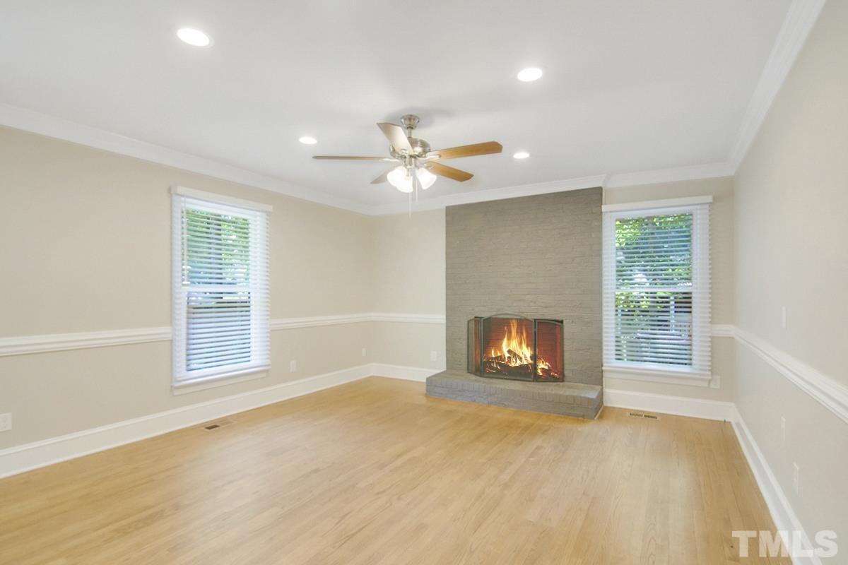 500 Chapwith Road Garner, NC 27529 - Photo 4 of 28 an empty room with a fireplace and windows