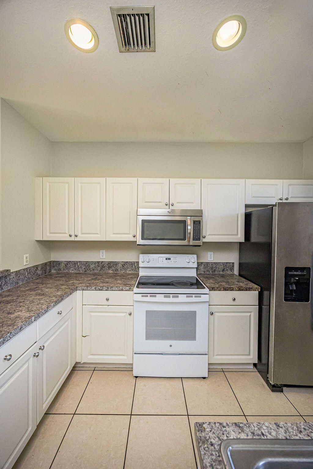 970 Tortuga Drive Riviera Beach, FL 33404 - Photo 12 of 37 a kitchen with a stove top oven and cabinets
