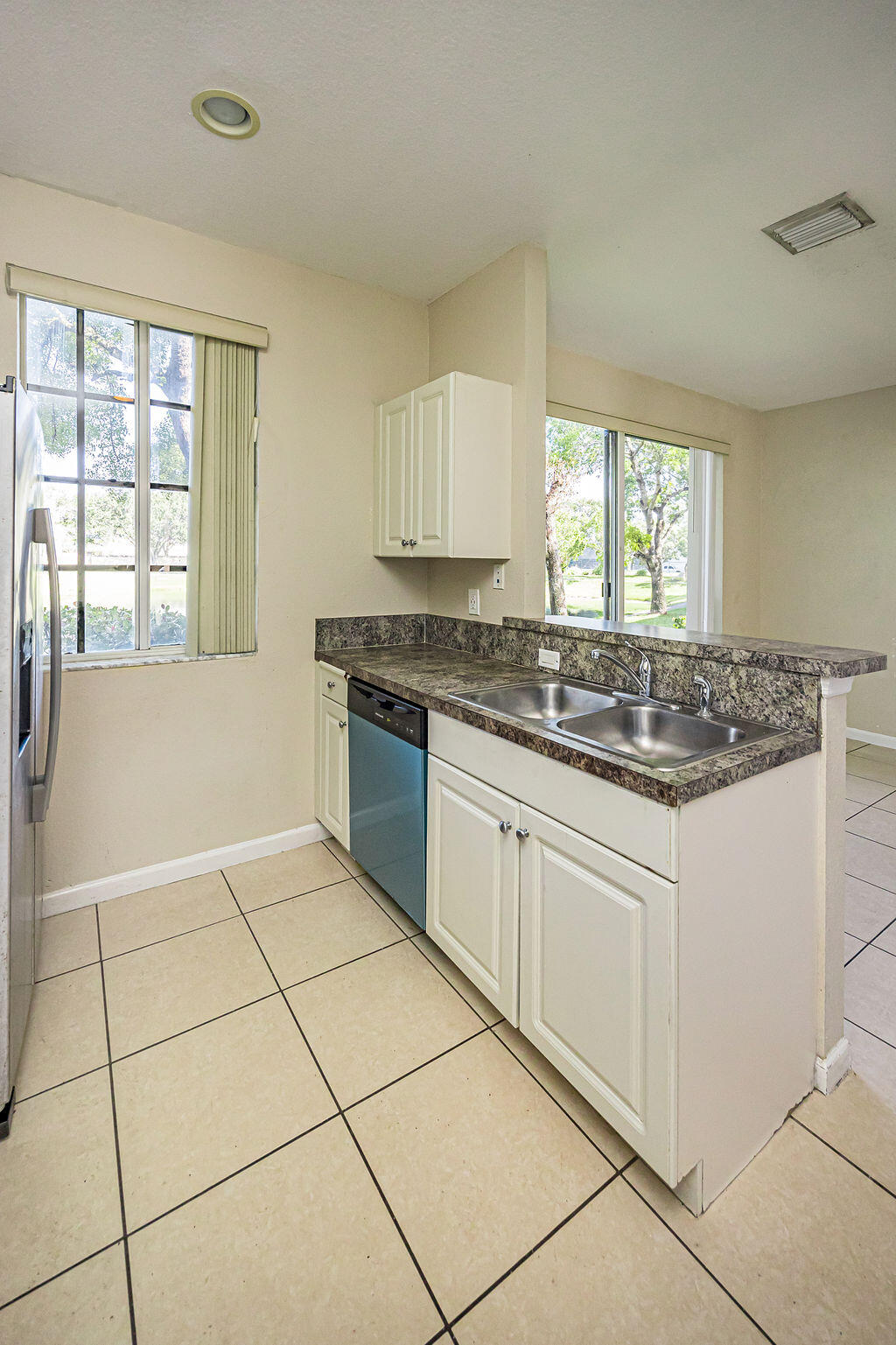 970 Tortuga Drive Riviera Beach, FL 33404 - Photo 13 of 37 a kitchen with granite countertop a stove sink and cabinets