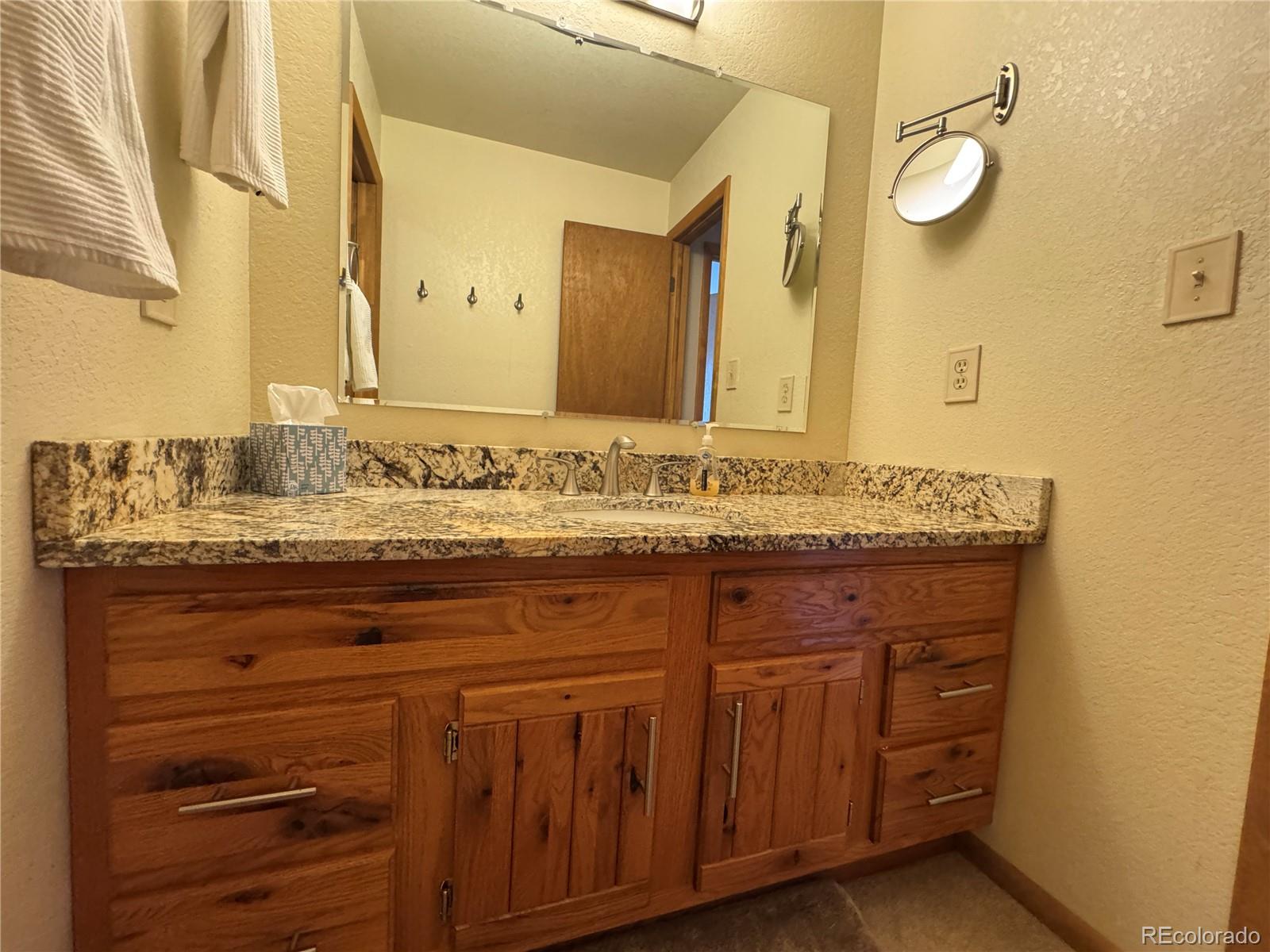 70 Highpoint Circle Black Hawk, CO 80422 - Photo 27 of 37 a bathroom with a granite countertop sink and a mirror