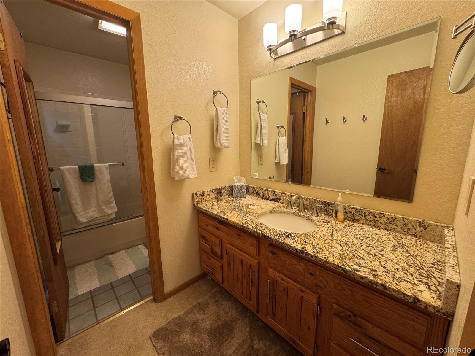 70 Highpoint Circle Black Hawk, CO 80422 - Photo 28 of 37 a bathroom with a granite countertop sink and a mirror