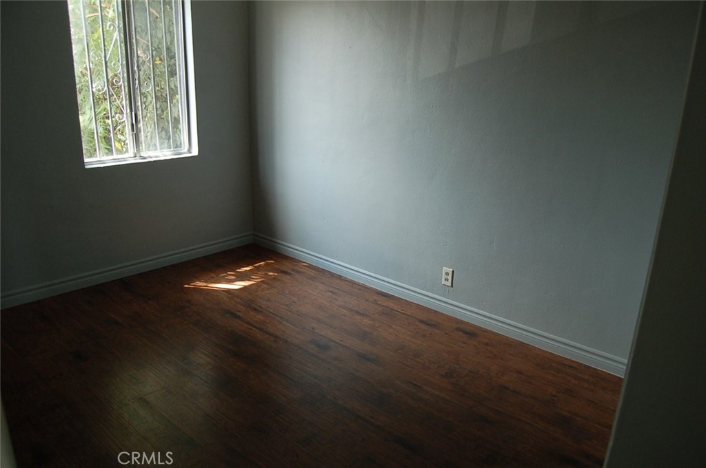 422 West Palm Street, Unit 424 1/2D Compton, CA 90220 - Photo 7 of 17 an empty room with wooden floor and windows