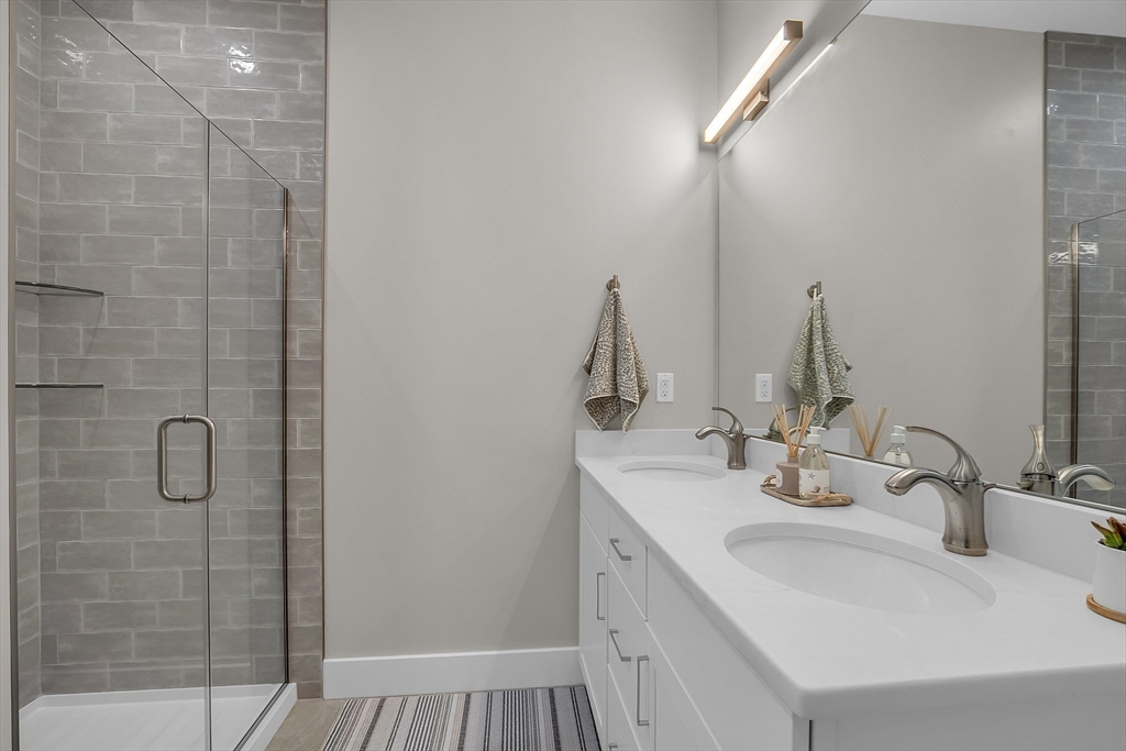55 Pointe Place, Unit 304 Dover, NH 03820 - Photo 28 of 42 a bathroom with a double vanity sink and a mirror