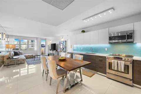 a kitchen with stainless steel appliances granite countertop a stove a sink a dining table and chairs