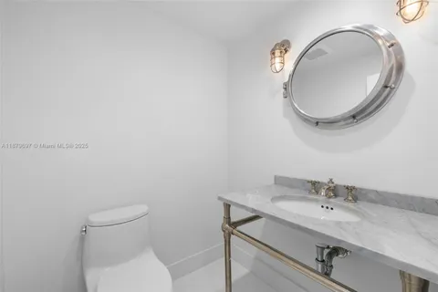 a bathroom with a granite countertop toilet a sink and mirror