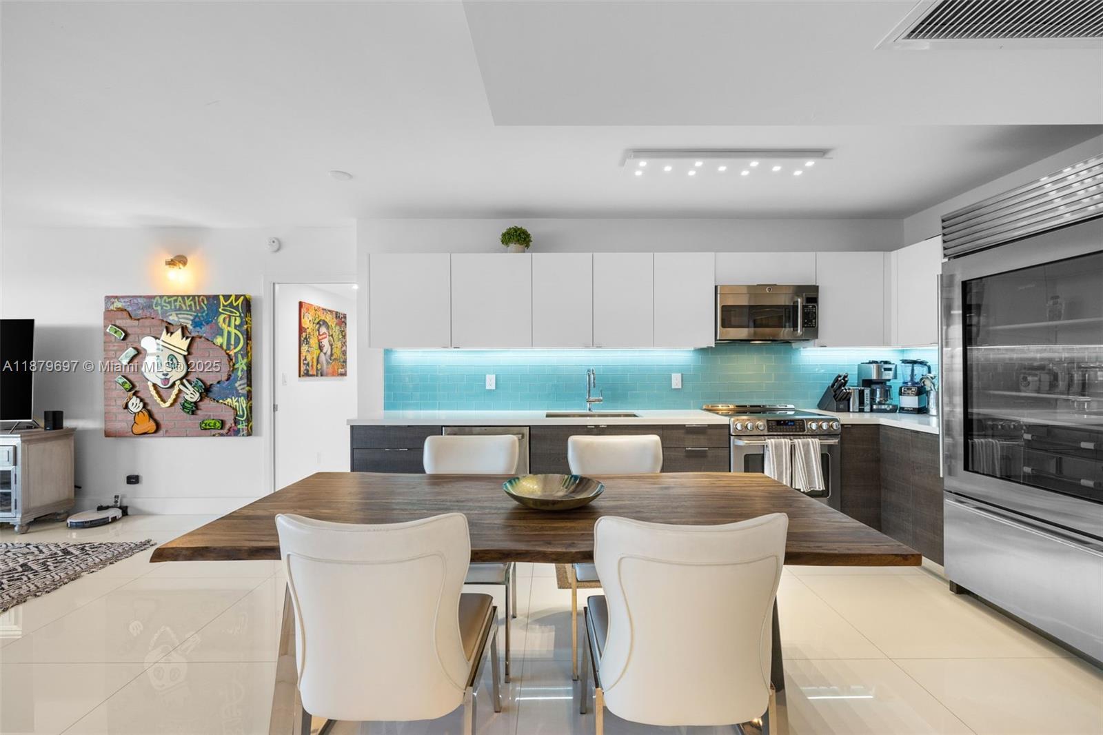 100 Lincoln Road, Unit 1523/1525 Miami Beach, FL 33139 - Photo 4 of 35 a kitchen with stainless steel appliances kitchen island granite countertop a table and chairs