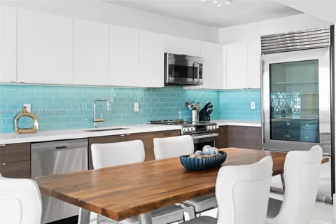 a view of a kitchen with kitchen island a dining table and chairs