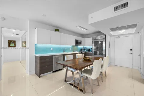 a kitchen with granite countertop white cabinets and stainless steel appliances