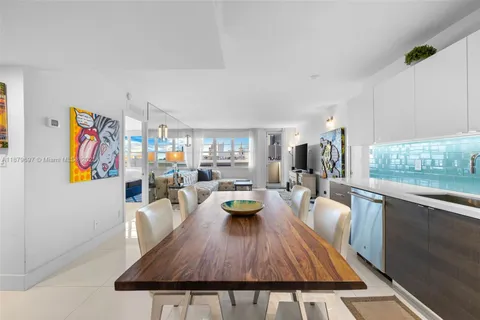a view of a dining room with furniture a kitchen and chandelier
