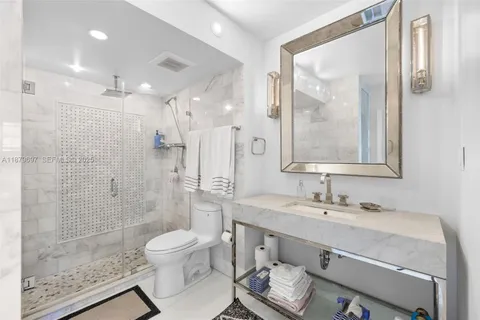 a bathroom with a sink toilet a mirror and shower