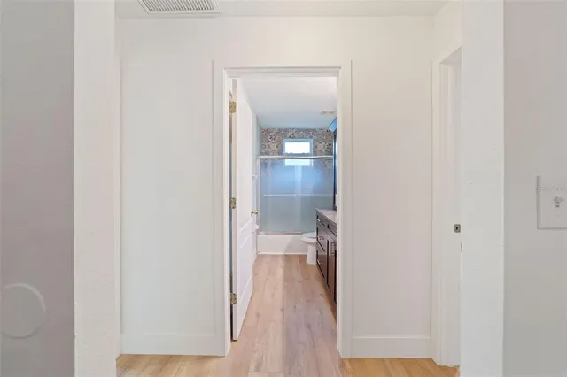 a view of empty room with wooden floor and window