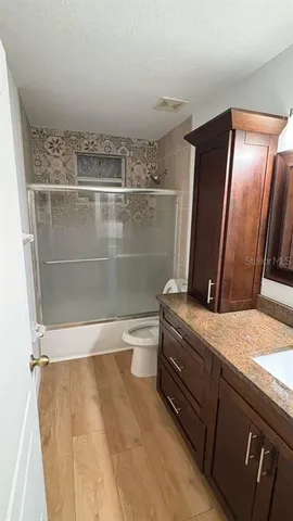 a bathroom with a granite countertop sink mirror and toilet