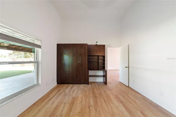 a view of empty room with wooden floor and window