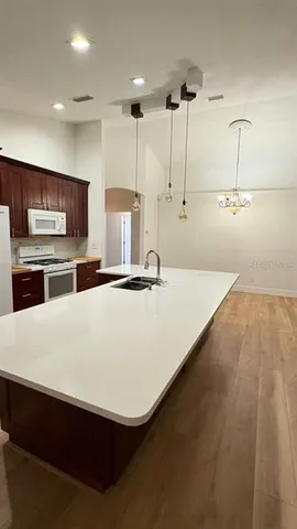 a kitchen with stainless steel appliances granite countertop a sink a stove and a wooden floors