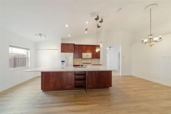 a view of kitchen with stainless steel appliances granite countertop cabinets and wooden floor