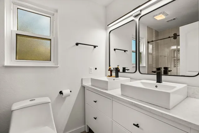 a bathroom with a double vanity sink and mirror