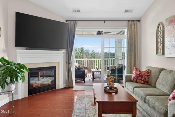 a living room with furniture a flat screen tv and a fireplace
