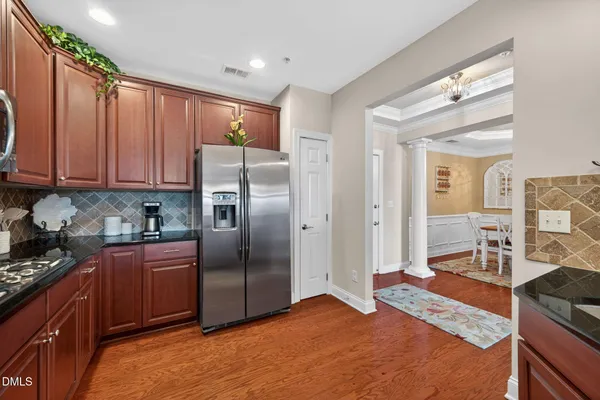 a kitchen with stainless steel appliances granite countertop a refrigerator and a stove top oven