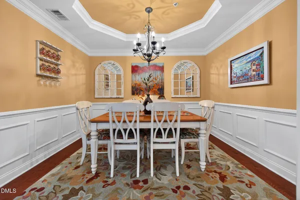 a view of a dining room with furniture a chandelier and wooden floor