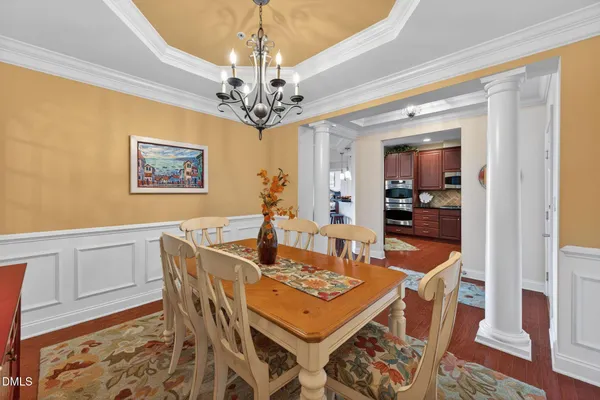 a view of a dining room with furniture a chandelier and wooden floor