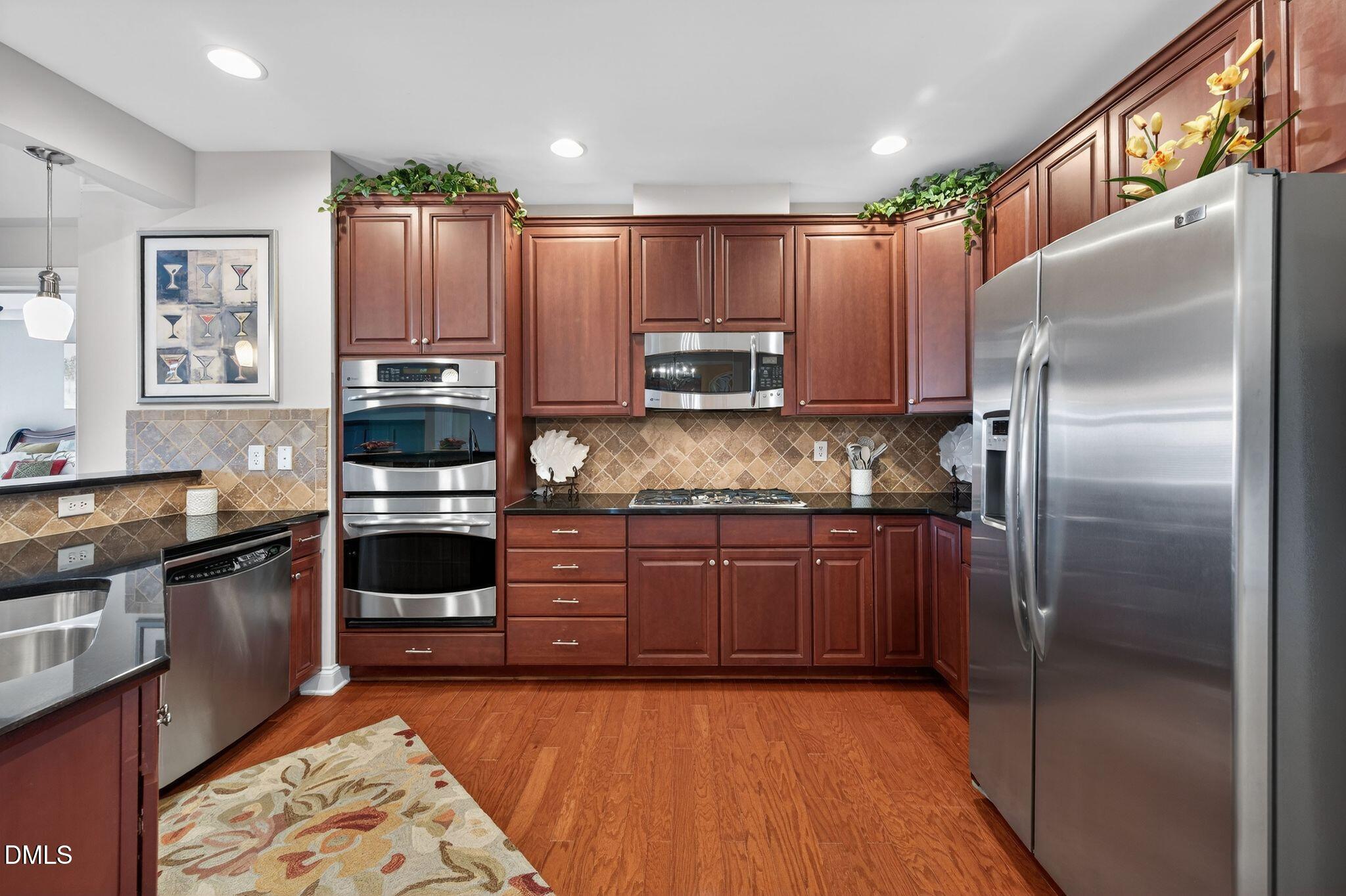 10511 Rosegate Court, Unit 305 Raleigh, NC 27617 - Photo 10 of 48 a kitchen with stainless steel appliances granite countertop a refrigerator a stove and a sink with wooden cabinets