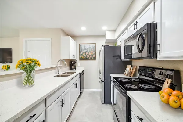 a kitchen with stainless steel appliances granite countertop a sink stove and refrigerator