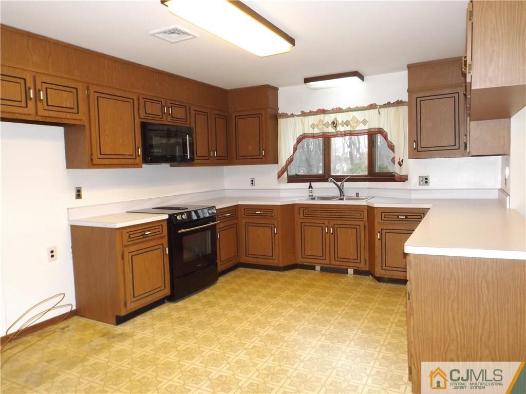 218 Docks Corner Road Dayton, NJ 08810 - Photo 7 of 21 a kitchen with a stove a sink and a microwave