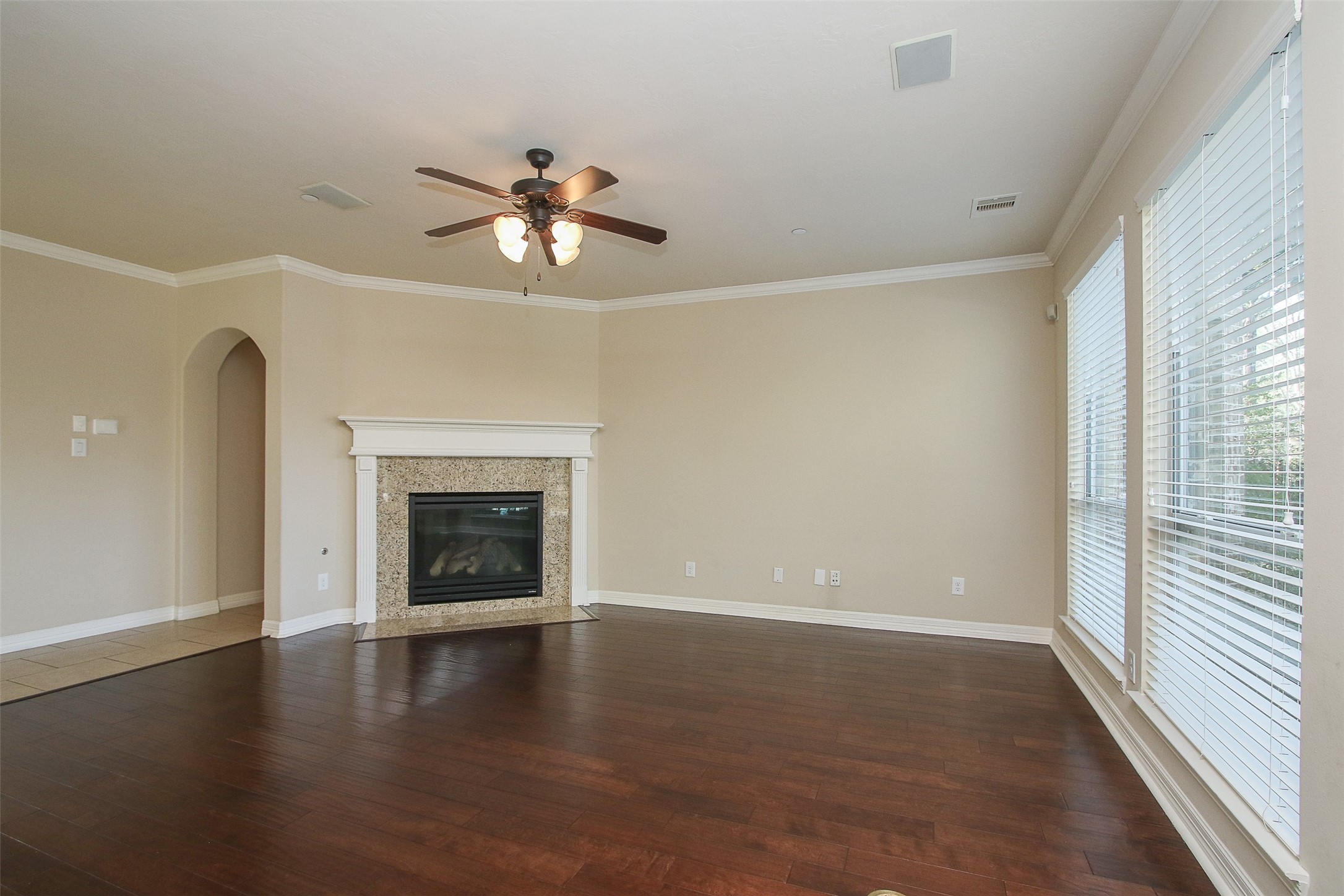 11722 Spriggs Way Houston, TX 77024 - Photo 13 of 49 a view of a livingroom with a fireplace a ceiling fan and wooden floor