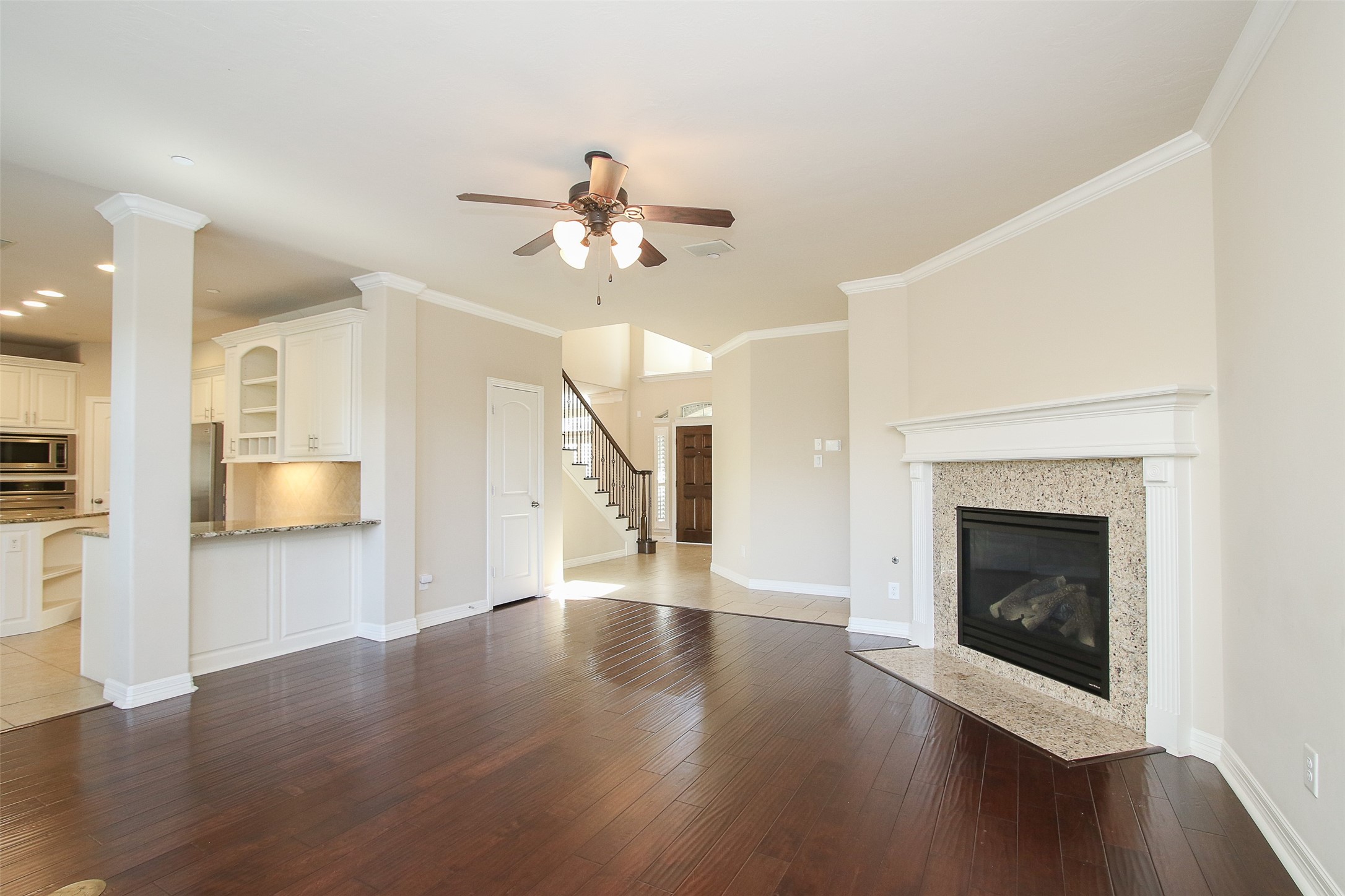 11722 Spriggs Way Houston, TX 77024 - Photo 14 of 49 a view of an empty room with wooden floor fireplace and a window
