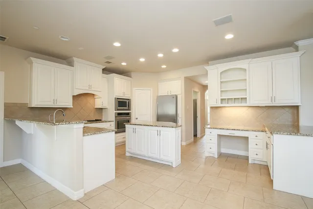 a kitchen with cabinets and chairs