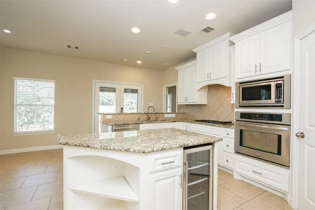 a kitchen with granite countertop white cabinets and white appliances