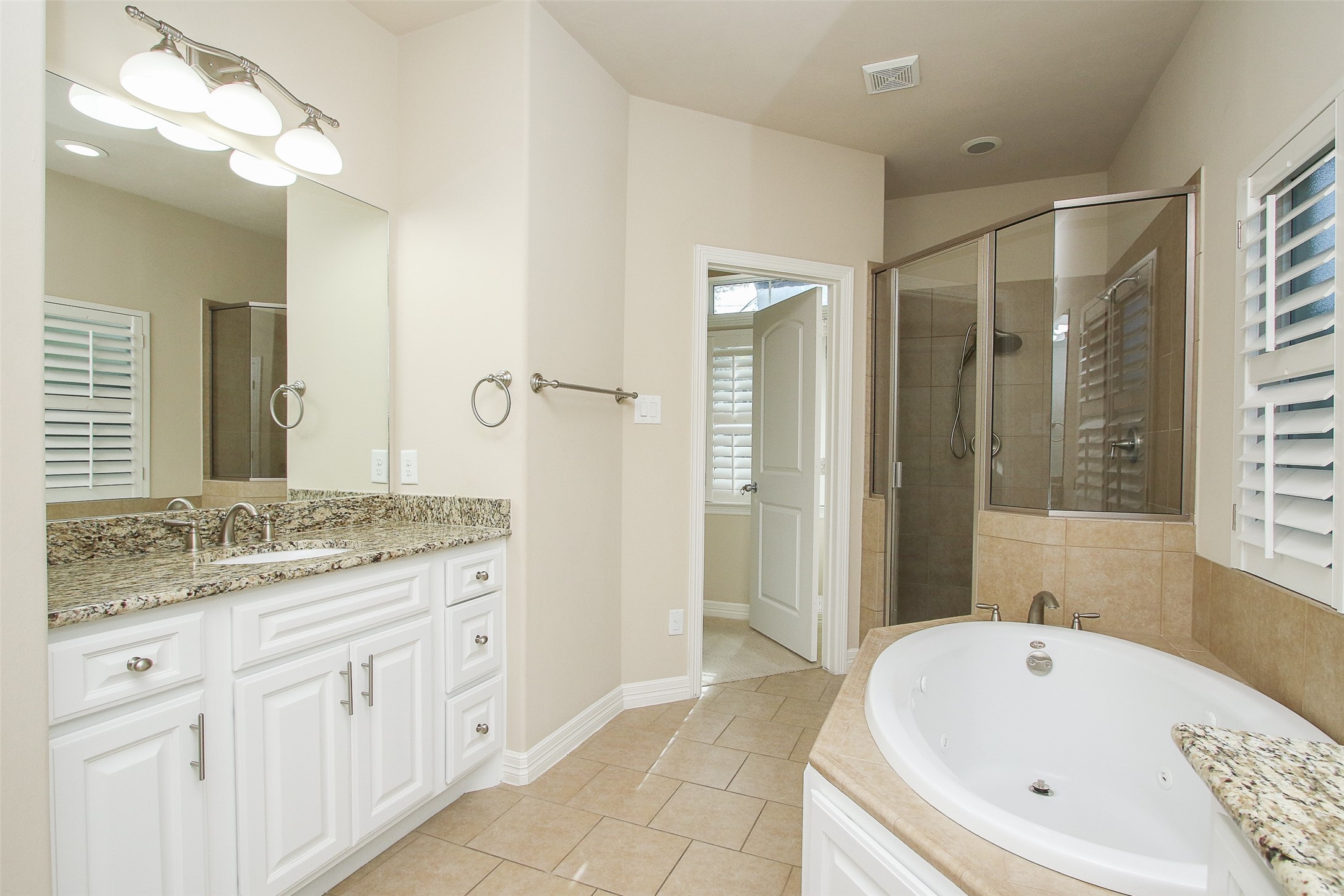 11722 Spriggs Way Houston, TX 77024 - Photo 25 of 49 a bathroom with a tub a sink and a large mirror