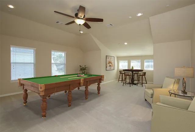 a room with furniture pool table and windows