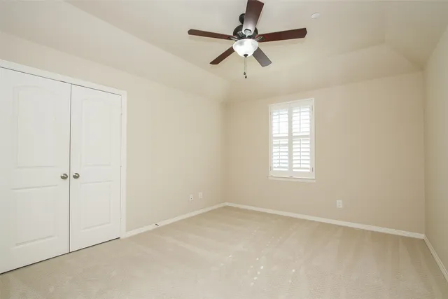 an empty room with a window and a fan