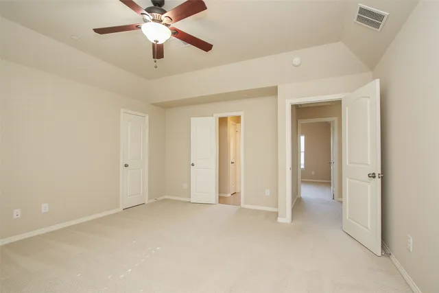 an empty room with closet and a chandelier fan