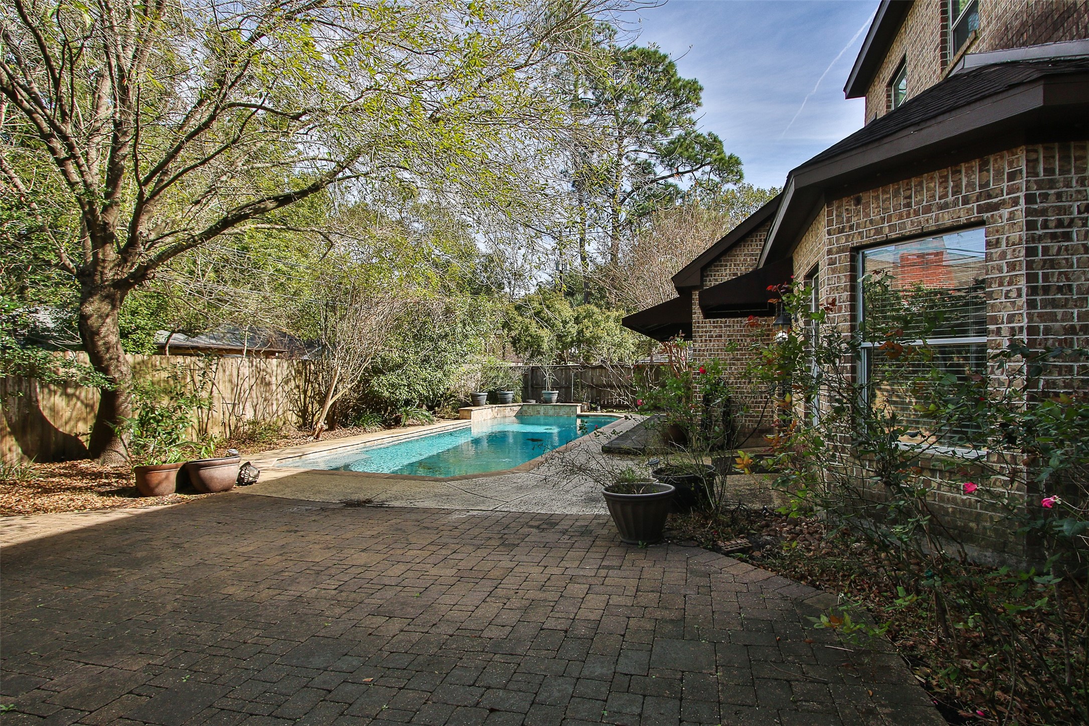 11722 Spriggs Way Houston, TX 77024 - Photo 44 of 49 a backyard of a house with fountain and barbeque oven