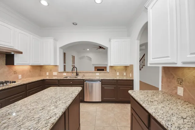 a kitchen with a sink a stove and cabinets