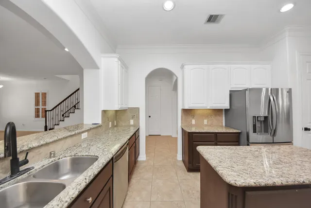 a kitchen with stainless steel appliances granite countertop a sink and a refrigerator