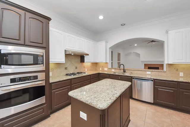 a kitchen with stainless steel appliances granite countertop a kitchen island a stove and a sink