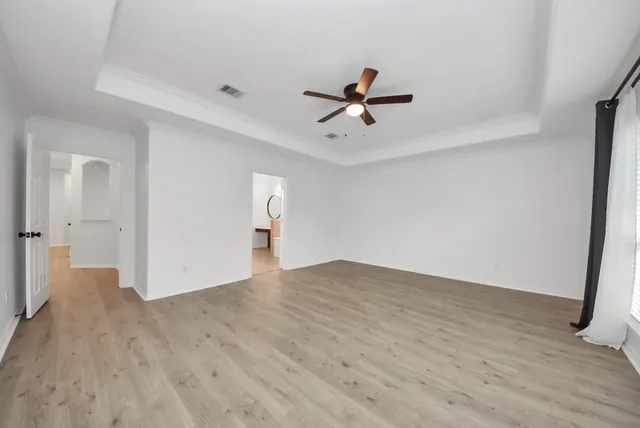 a view of empty room with wooden floor