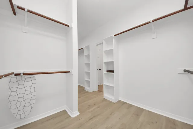 a view of walk in closet with wooden floor