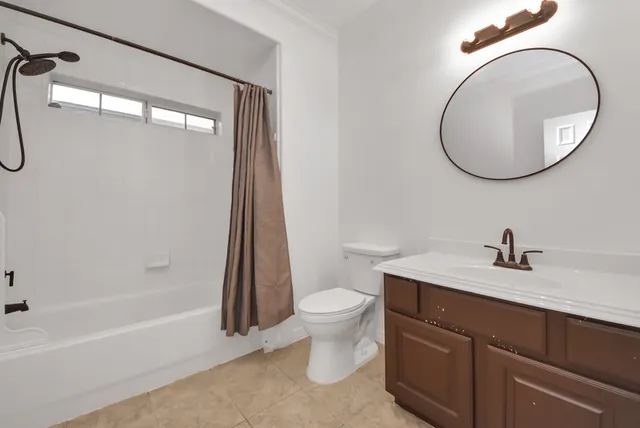 a bathroom with a granite countertop sink a toilet and a mirror