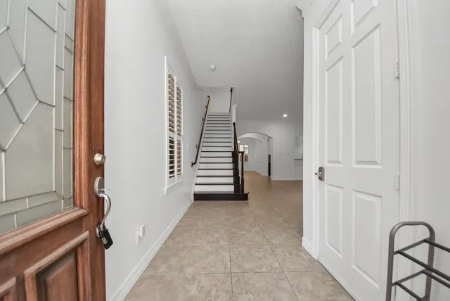 a view of a hallway with stairs and furniture