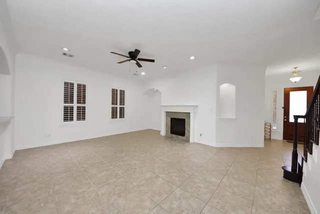 an empty room with fireplace and windows
