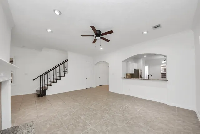 an empty room with ceiling fan and entryway