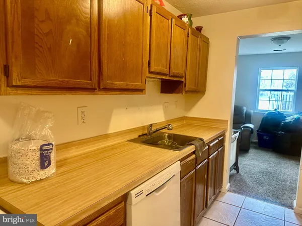 a utility room with stainless steel appliances wooden floor and a window