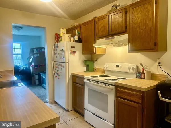 a kitchen with a stove top oven a sink and a refrigerator
