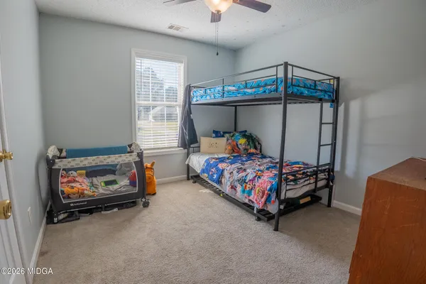 a bedroom with a bed and a baby crib